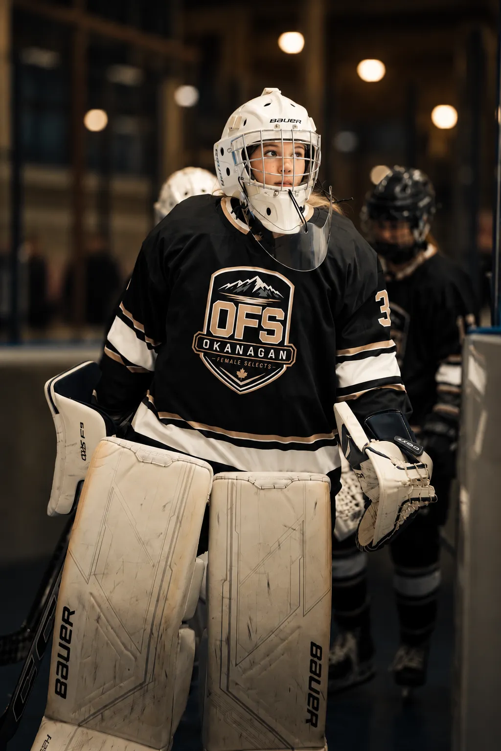 OFS goalie in her white mask and OFS crest jersey heading to the ice
